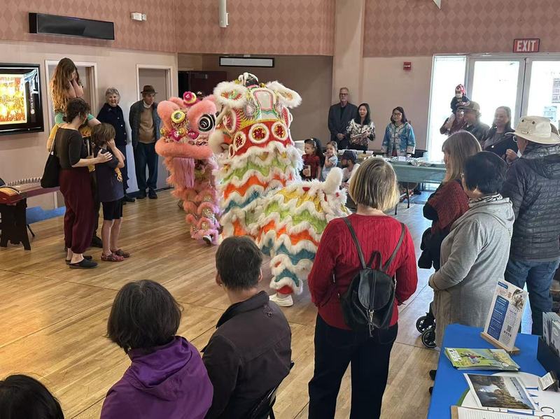 Children and families watch a colorful lion dance