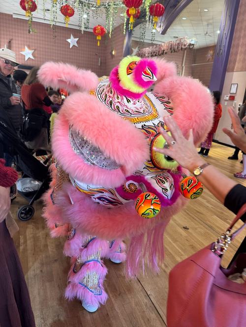 A lion dancer greets guests at The 418 Project